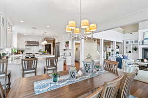 Dining area with stairs, wood finished floors, recessed lighting, and a notable chandelier