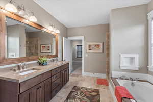 Bathroom with a bath, a sink, double vanity, and tiled shower