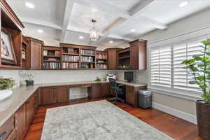 Home office with built in study area, coffered ceiling, dark wood-style flooring, beam ceiling, and recessed lighting