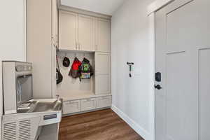 Mudroom featuring baseboards and dark wood-type flooring