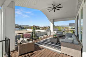 Wooden terrace with a ceiling fan, outdoor lounge area, a mountain view, and a residential view