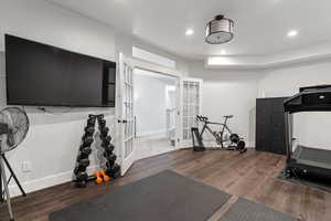 Workout area featuring baseboards, wood finished floors, and recessed lighting