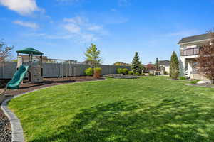 View of yard featuring fence and a playground