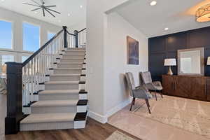 Stairs with recessed lighting, wood finished floors, and baseboards