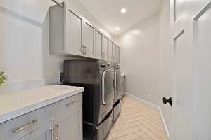 Laundry area with cabinet space, independent washer and dryer, baseboards, and recessed lighting