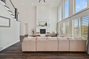 Living area featuring a fireplace, visible vents, a towering ceiling, and baseboards