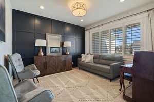Living area featuring recessed lighting and a decorative wall