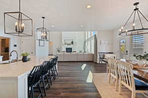 Dining room with an inviting chandelier, dark wood-style floors, and recessed lighting
