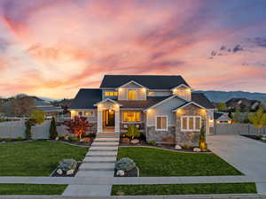 Craftsman-style home with a gate, stone siding, a front lawn, and concrete driveway
