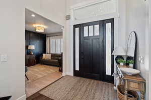 Entryway with baseboards, wood finished floors, and recessed lighting