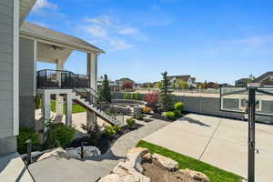 View of patio featuring ceiling fan, a fenced backyard, stairs, and a residential view
