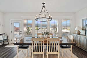 Dining room with a chandelier and dark wood-style flooring