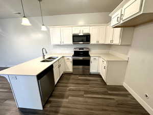 Kitchen featuring a sink, stainless steel appliances, white cabinets, a peninsula, and visible vents