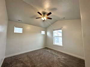Unfurnished room with visible vents, ceiling fan, vaulted ceiling, and baseboards