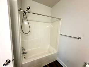 Bathroom with baseboards, wood finished floors, and shower / bath combination