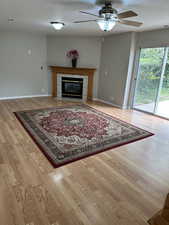 Living room featuring visible vents, wood finished floors, a textured ceiling, and ceiling fan