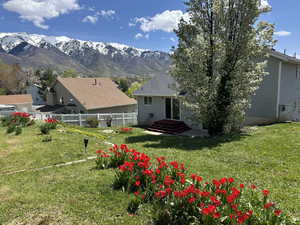 Back of property featuring a lawn, fence, and a mountain view