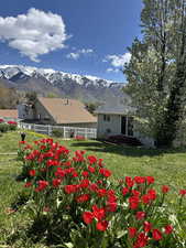 View of yard featuring a deck with mountain view and fence