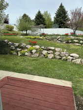 View of yard featuring fence and a deck