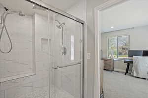 Ensuite bathroom featuring baseboards, ensuite bath, and a stall shower