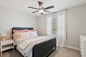 Carpeted bedroom featuring baseboards and ceiling fan