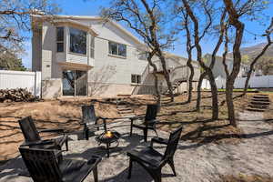 Rear view of house featuring stairs, fence, a patio area, an outdoor fire pit, and brick siding