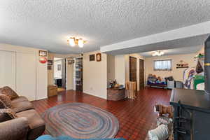 Living area featuring baseboards and a textured ceiling