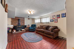 Living area with a textured ceiling and a wood stove