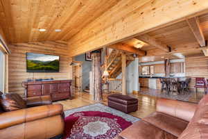 Living room featuring rustic walls, light wood-style flooring, and wood ceiling