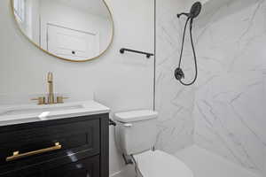 Full bath featuring toilet, walk in shower, and vanity
