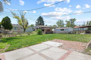 View of yard featuring fence, a residential view, and a patio
