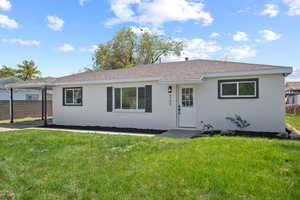 Single story home featuring a carport, fence, a front yard, and brick siding