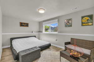 Bedroom with baseboards, wood finished floors, and visible vents
