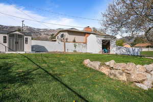 View of yard with fence, 2 sheds, and a mountain view