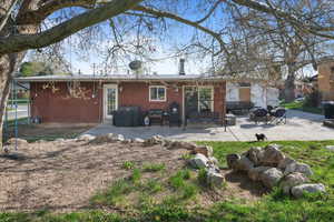 Rear view of property featuring fence, a patio area, and brick siding