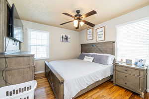 Bedroom featuring wood finished floors, baseboards, and ceiling fan