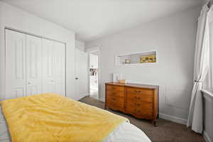 Bedroom with baseboards, carpet floors, and a closet