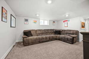 Carpeted living area featuring baseboards and recessed lighting