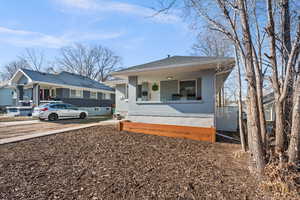 Bungalow-style house with brick siding, roof with shingles, and covered porch