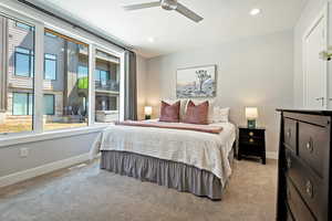 Bedroom featuring baseboards, visible vents, light colored carpet, and multiple windows