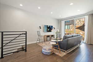 Living area with baseboards, wood finished floors, and recessed lighting