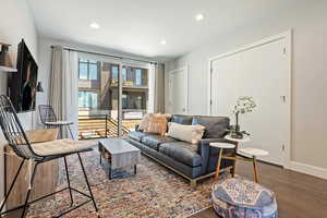 Living area featuring baseboards, wood finished floors, and recessed lighting