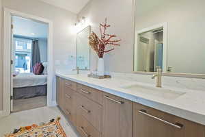 Bathroom with connected bathroom, a sink, and double vanity