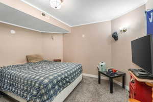 Bedroom featuring baseboards, visible vents, carpet, and crown molding