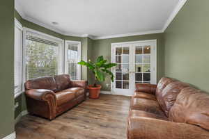 Living room with baseboards, french doors, wood finished floors, and a wealth of natural light