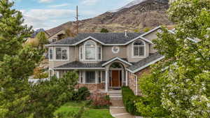 Traditional-style house featuring stone siding, stucco siding, and a mountain view