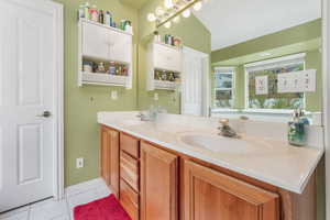 Full bath featuring tile patterned flooring, a sink, and double vanity