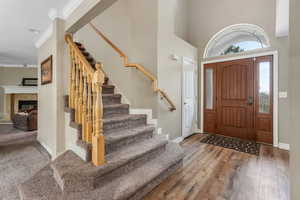 Entryway with crown molding, baseboards, stairway, and a healthy amount of sunlight