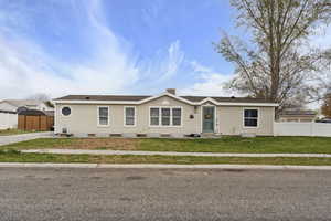 Manufactured / mobile home featuring fence, a front lawn, a storage shed, an outdoor structure, and roof with shingles