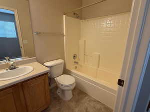 Bathroom with tile patterned flooring, toilet, vanity, and washtub / shower combination